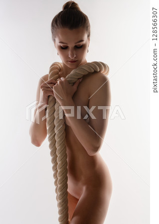 Woman posing confidently with a rope in a studio setting focusing on sport 128566307