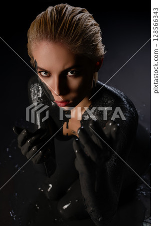 Striking beauty showcases body art with intricate paint and tattoos 128566343