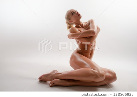 Elegant woman in an athletic pose showcases beauty and strength Elegant woman in an athletic pose showcases beauty and strength 128566923
