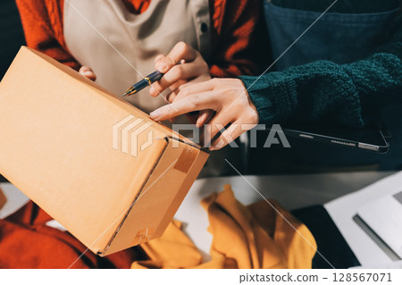 Portrait of Starting small businesses SME owners, two Asian woman check online orders Selling products working with boxs freelance work at home office, sme business online small medium enterprise 128567071