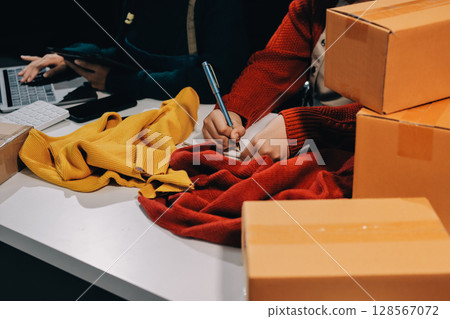 Portrait of Starting small businesses SME owners, two Asian woman check online orders Selling products working with boxs freelance work at home office, sme business online small medium enterprise 128567072