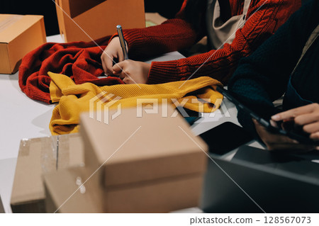 Portrait of Starting small businesses SME owners, two Asian woman check online orders Selling products working with boxs freelance work at home office, sme business online small medium enterprise Portrait of Starting small businesses SME owners, two Asian woman check online orders Selling products working with boxs freelance work at home office, sme business online small medium enterprise 128567073
