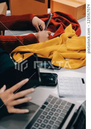 Portrait of Starting small businesses SME owners, two Asian woman check online orders Selling products working with boxs freelance work at home office, sme business online small medium enterprise Portrait of Starting small businesses SME owners, two Asian woman check online orders Selling products working with boxs freelance work at home office, sme business online small medium enterprise 128567074