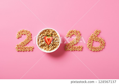 Numbers 2026 made from cereal rings on pink background. Concept of delicious New Year. Numbers 2026 made from cereal rings on pink background. Concept of delicious New Year. 128567137