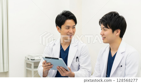 Asian doctor, a senior doctor teaching a junior doctor how to do his job 128568277