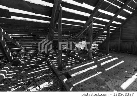 Dark interior view with wooden structure showcasing exposed beams Dark interior view with wooden structure showcasing exposed beams 128568387