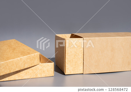 Cardboard packaging box set with open lid on gray background. International Box Day Cardboard packaging box set with open lid on gray background. International Box Day 128568472