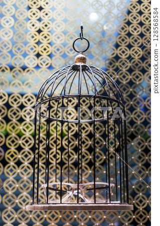 Glasses in hanging metal cage in store window 128568584