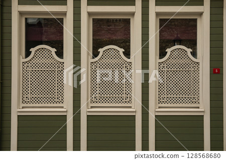 Lattice patterns enhance the charm of a green facade in the city Lattice patterns enhance the charm of a green facade in the city 128568680