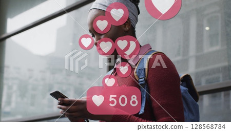 Image of social media heart icons over smiling african american woman using smartphone in street Image of social media heart icons over smiling african american woman using smartphone in street 128568784