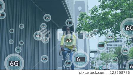 Image of 6g icons over african american woman riding bike in city street 128568786
