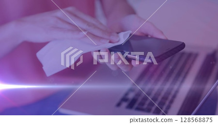 Image of caucasian woman wiping her smartphone with purple tint Image of caucasian woman wiping her smartphone with purple tint 128568875