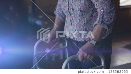 Image of light moving over midsection of senior woman using walking frame Image of light moving over midsection of senior woman using walking frame 128568963