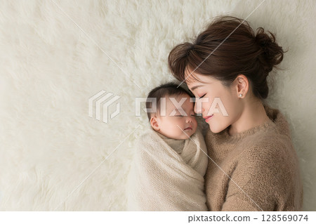 Baby and mom sleeping together 128569074
