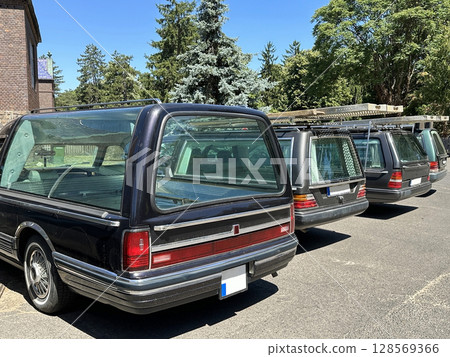 Hearses in a row at the cemetery Hearses in a row at the cemetery 128569366