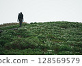 Climbers walking through a flower field 128569579