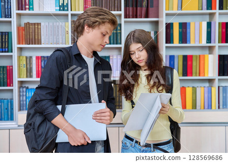 Portrait of two teenage students classmates boy and girl talking at school 128569686