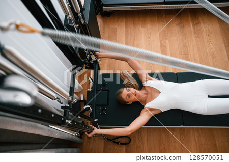 Slim body type. Young woman in fitness center is doing exercises 128570051