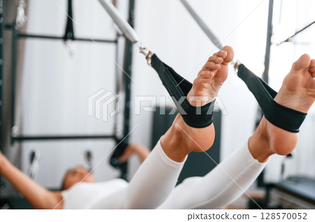 Young woman in fitness center is doing exercises Young woman in fitness center is doing exercises 128570052
