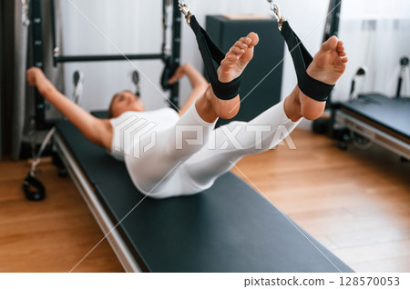 Young woman in fitness center is doing exercises Young woman in fitness center is doing exercises 128570053
