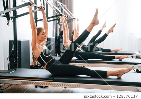 Doing abs exercises by lifting the legs. Women in fitness center Doing abs exercises by lifting the legs. Women in fitness center 128570137