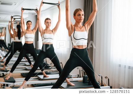 Exercises by using the circle device in hands. Women in fitness center Exercises by using the circle device in hands. Women in fitness center 128570151