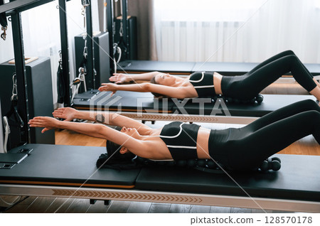 Using device with circles for the spine. Women in fitness center are doing exercises Using device with circles for the spine. Women in fitness center are doing exercises 128570178