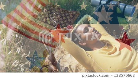 Image of american flag over biracial woman lying in mountains Image of american flag over biracial woman lying in mountains 128570668