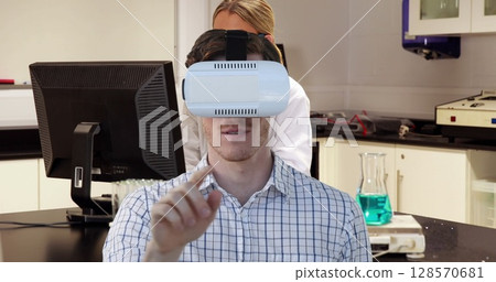 Image of man wearing vr headset over female scientist using computer Image of man wearing vr headset over female scientist using computer 128570681