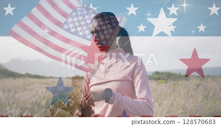 Image of american flag over biracial woman drinking water in mountains 128570683