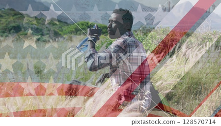 Image of american flag over african american man drinking water in mountains Image of american flag over african american man drinking water in mountains 128570714
