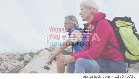 Image of independence day text over smiling senior caucasian couple sitting on rocks 128570735