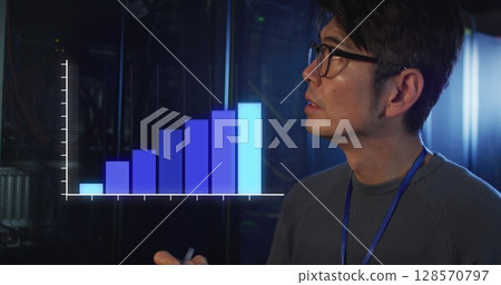 Image of statistics over asian male it engineer with clipboard by computer server 128570797