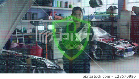 Image of padlock and shield icon over biracial female car mechanic using tablet at garage 128570980