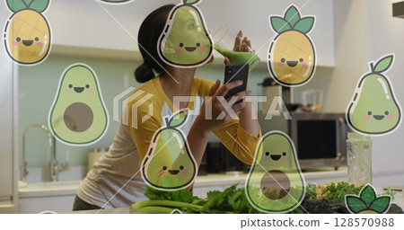 Image of smiling fruits over biracial woman having health drink and using smartphone at home Image of smiling fruits over biracial woman having health drink and using smartphone at home 128570988