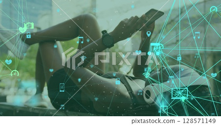 Image of media icons over biracial woman using smartphone Image of media icons over biracial woman using smartphone 128571149