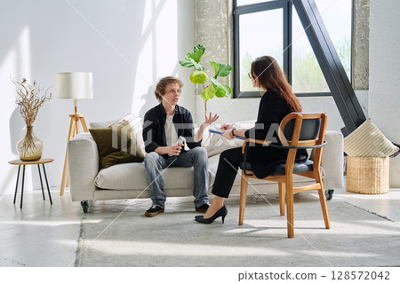 Teenage boy in mental therapy session, talking with behavioral psychologist Teenage boy in mental therapy session, talking with behavioral psychologist 128572042