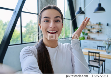 Close-up selfie portrait of teenage female looking at web camera Close-up selfie portrait of teenage female looking at web camera 128572081
