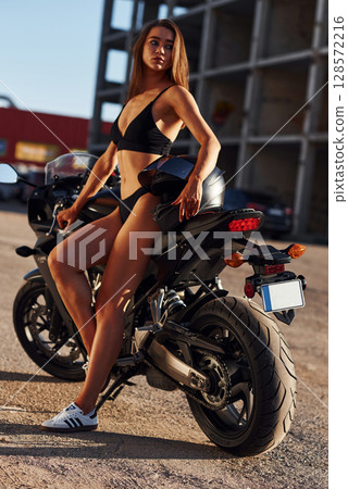 Hot woman in underwear is with motorcycle outdoors Hot woman in underwear is with motorcycle outdoors 128572216