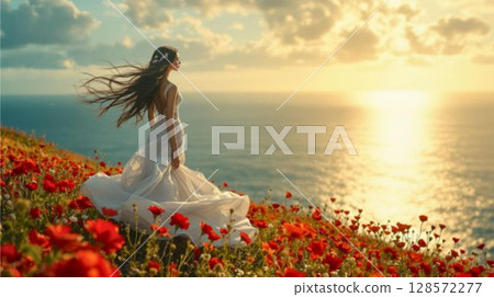 Beautiful woman standing among red flowers illuminated by the setting sun 128572277