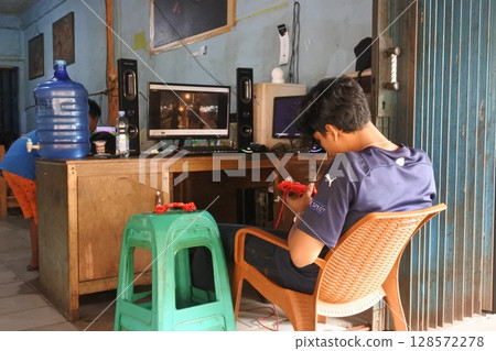 Jambi, Indonesian - July 15 2025 : Person Engages in Relaxing Activity in Front of Computer Screen 128572278