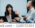 Business executives discussing startup investment losses in boardroom meeting 128572303