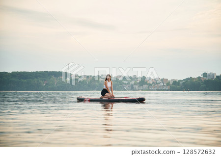 Young woman is on sup boards in the lake Young woman is on sup boards in the lake 128572632