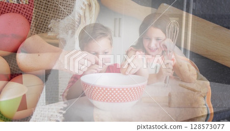 Image of caucasian family baking in kitchen over eggs and basket 128573077