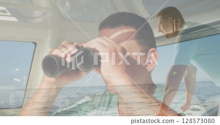 Image of caucasian man using binoculars over caucasian man sailing 128573080