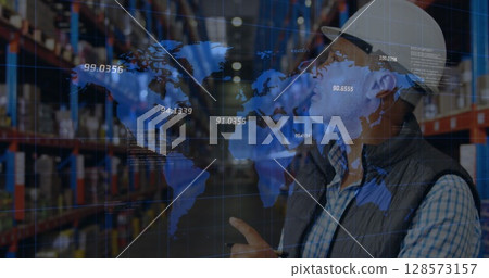 Image of financial data processing and world map over biracial worker in warehouse 128573157