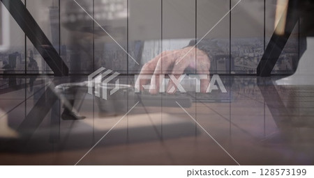 Image of hand of caucasian man using computer over cityscape 128573199