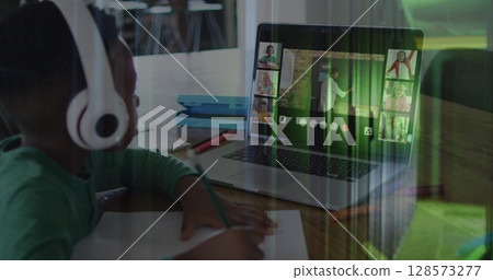 Image of african american schoolboy on laptop online learning over computer servers 128573277