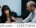 Modern office team meeting with presentation screen and professional executives brainstorming 128573844