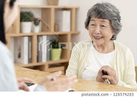 Senior woman receiving a home visit survey, care manager, care manager Senior woman receiving a home visit survey, care manager, care manager 128574283